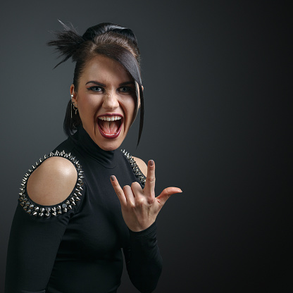 Screaming aggressive woman punk on a black background.