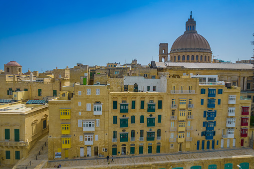 Aerial view of Basilica Lady of Mount Carmel church, St. Paul's Cathedral in the old town of Valetta, Malta. Colorful balconies of Malta capital from above on a sunny day