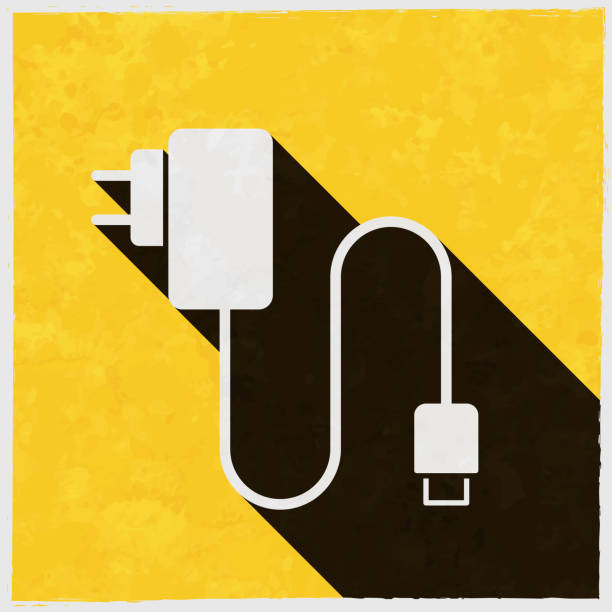 휴대 전화 충전기. 질감이 있는 노란색 배경에 긴 그림자가 있는 아이콘 - electric plug electricity power cable power stock illustrations