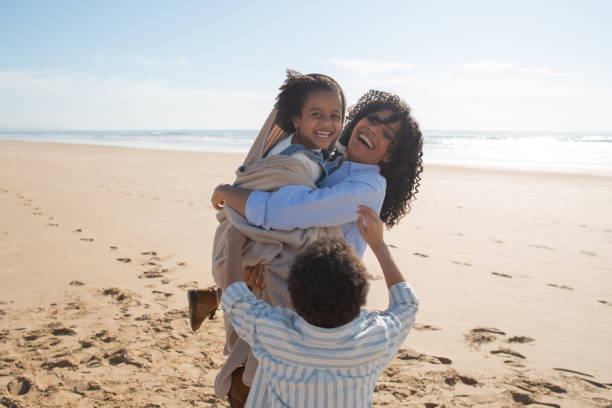 istock Cheerful mother and children spending time on beach 1396123215