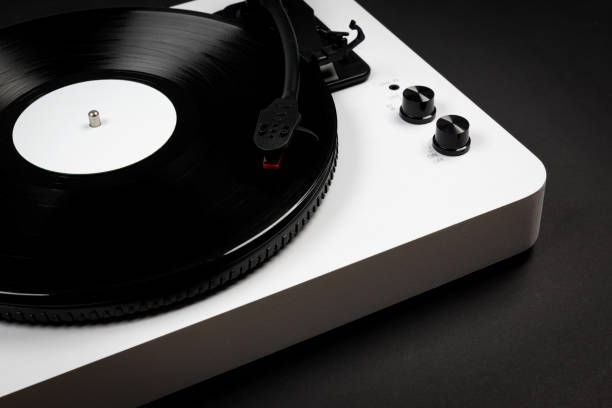 istock Vinyl turntable with vinyl plate on a black background. Modern gramophone record player. Retro sound technology to play music 1396126326