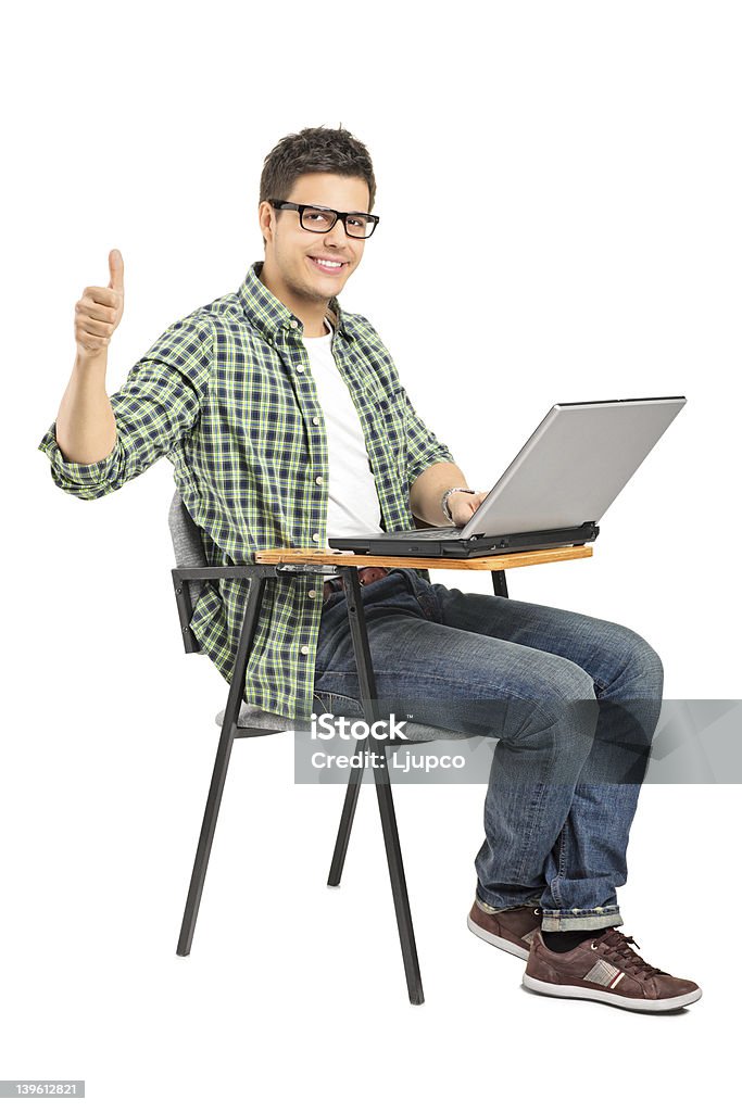 Menino de escola, trabalhando em um laptop e dando polegares para cima - Foto de stock de Escrivaninha royalty-free