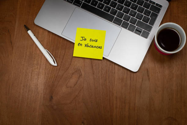 istock a message in French is written on a yellow self-adhesive paper and placed on a computer keyboard: I'm on vacation 1396130263