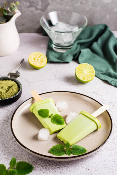 Vegetarian popsicle made from matcha tea, coconut milk and mint on a plate. Vertical view