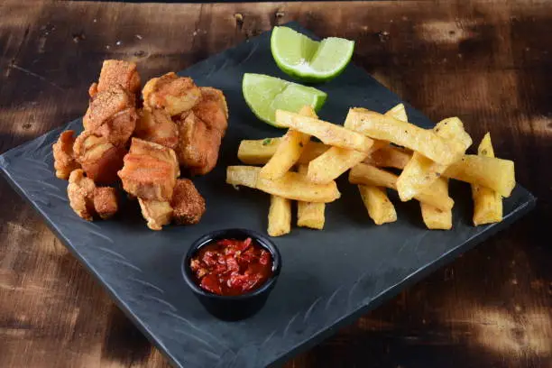 Photo of pork cracklings with fried cassava and lemon pork bacon