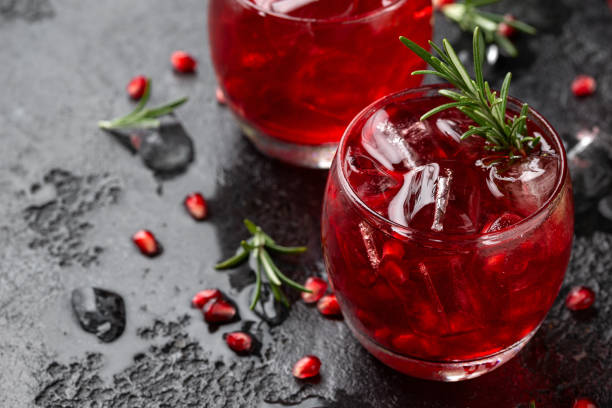 istock Pomegranate gin cocktail with lime, rosemary and ice on rustic black table 1396133672