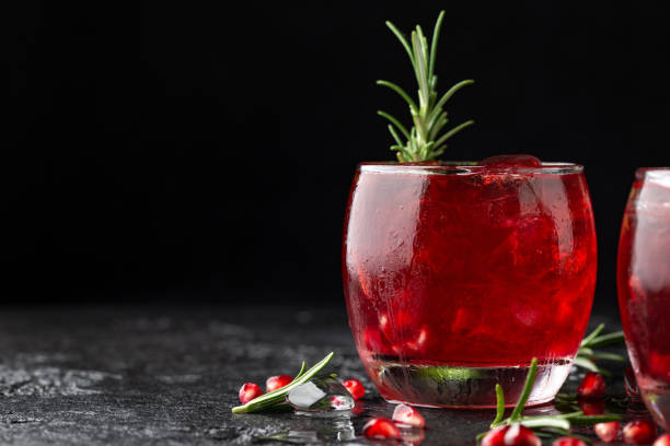 istock Pomegranate gin cocktail with lime, rosemary and ice on rustic black table 1396133714
