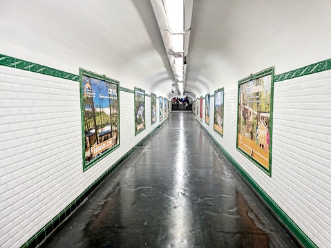 Paris Métro with a long connection tunnel with advertising at the walls. The image shows an empty tunnel connecting two different Metro Lines.