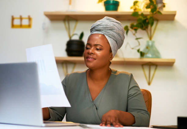 istock African business woman reading paperwork or document while sitting at her desk in a modern office. Female entrepreneur checking financial documents or statistics report 1396138149