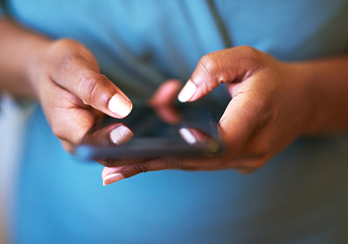 Close up of woman's hands typing on smartphone. Woman typing a message, surfing the internet or chatting on social network