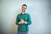 Portrait of a handsome man in a shirt standing in front of a white background.