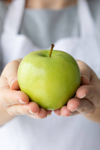 istock Woman Showing Green Apple 1396138448
