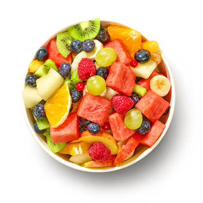 bowl of colorful fresh fruit salad for healthy meal isolated on white background, top view