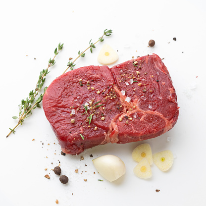 fresh raw beef steak meat and spices on white background, top view