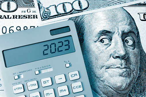 2023. Benjamin Franklin looking calculator on One Hundred Dollar Bill.