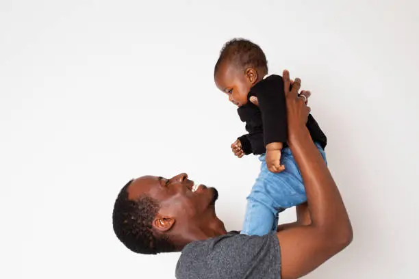 Young African descent Father holding his baby daughter in hands