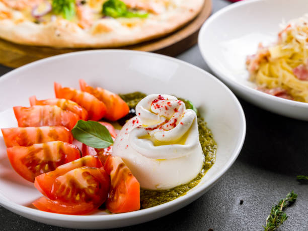 istock Salad with buratta cheese and tomatoes on bowl on grey table macro close up 1396145859