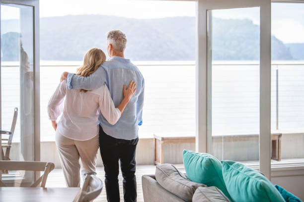istock Mature couple looking at the view in their waterfront home. 1396146997