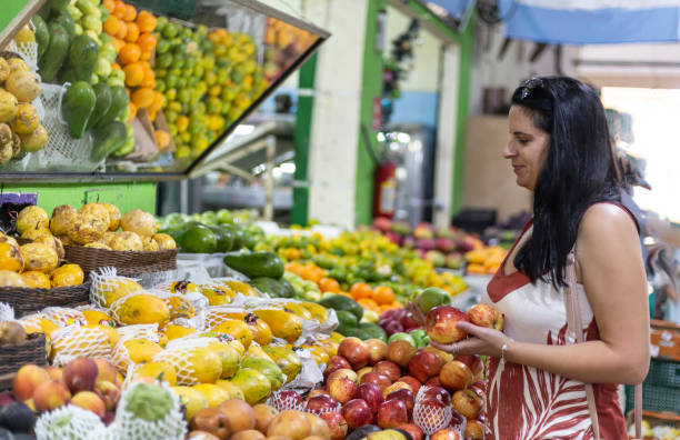 istock Black-haired woman choosing apples and pears at fruit stand 1396149842