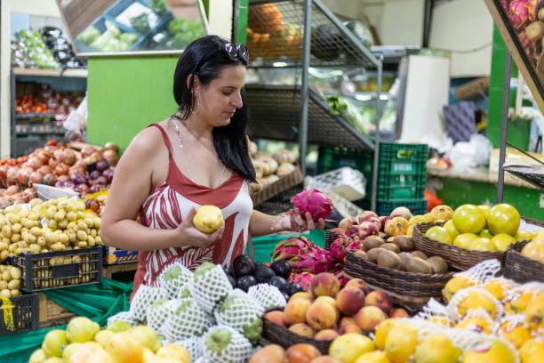 istock Black-haired woman with pitaya and pear at a fruit stand 1396149916
