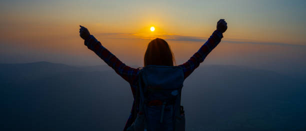 istock Female hiker silhouette with hand above head 1396151514