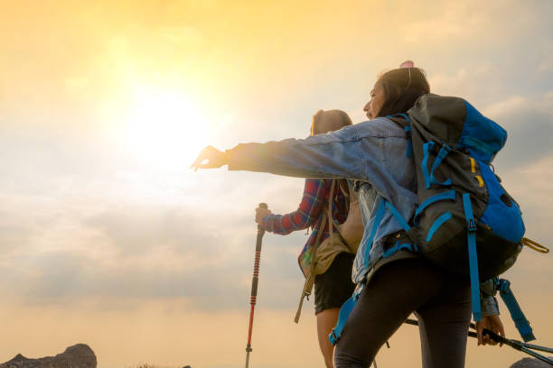 istock Female hikers on trip, view against sun shining through clouds 1396151536