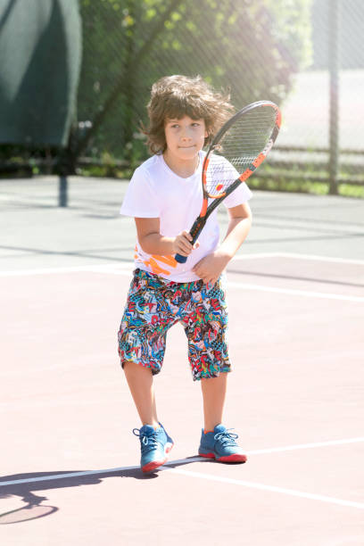 istock Happy boy playing tennis outdoors with a friend. 1396155503
