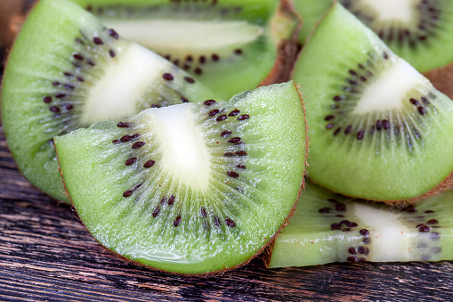 sliced kiwi fruit of green color, kiwi fruit cut it into thin slices during dessert cooking