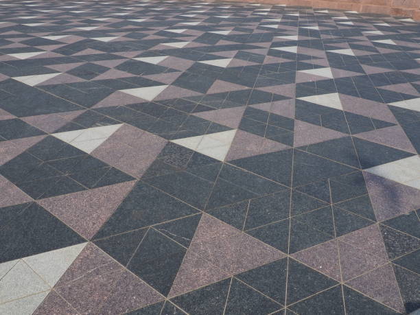 istock The square is paved with triangular tiles. Grey, white, black tiles on the street. The cobblestone surface. Modern design of streets, avenues, squares, shopping centers. Wear-resistant flooring. 1396160626