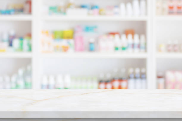 Empty white marble counter top with blur pharmacy drugstore shelves background stock photo