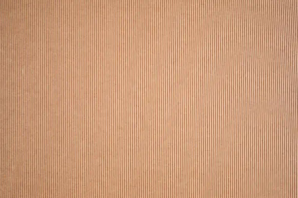 Kraft paper texture vertical striped ribbed pattern. Brown cardboard DIY hobby background.