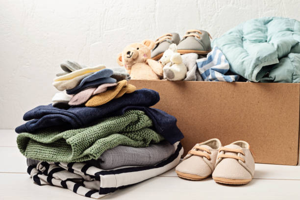 ropa para bebés y niños, juguetes en caja. idea de ropa de segunda mano. moda circular, donación, concepto de caridad - vestimenta fotografías e imágenes de stock