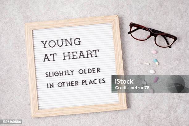 Letter Board With Text Young At Heart Slightly Older In Other Places Stock Photo - Download Image Now