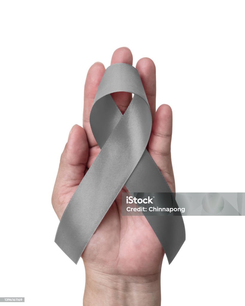 Grey or gray ribbon for Brain cancer and tumors awareness, allergies, asthma control and diabetes prevention. Bow on hand on white background Aphasia Stock Photo