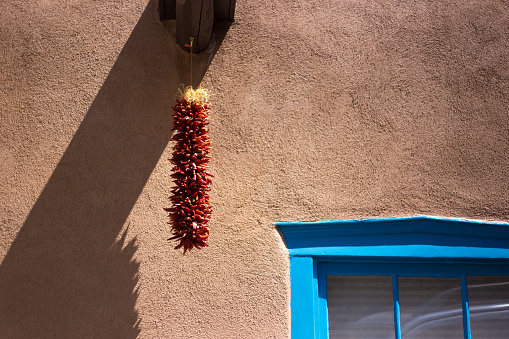 Santa Fe, NM: Chili Pepper Ristra, Sunlit Adobe Wall, Blue Window