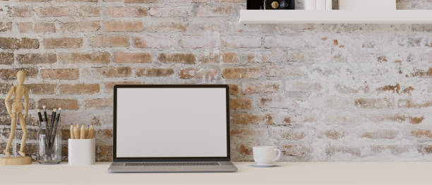 istock Minimal vintage workspace with laptop computer on white table over brick wall. 1396174495