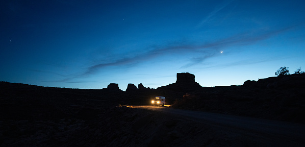 Van driving on a dirt road at night in Moab Utah, USA