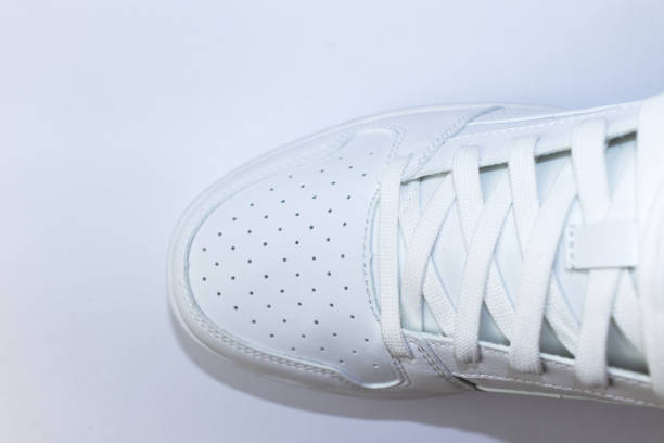 istock Top view of a white sneaker on a white background - white shoe with white laces 1396177401