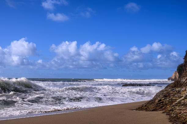 Turbulent ocean waves crashing on sandy beach, off the California Coast, after a pacific coast storm passed through the area.Taken at Davenport Landing, California, USA