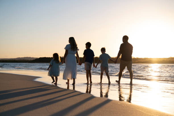 istock Family of five walking the beach 1396179043