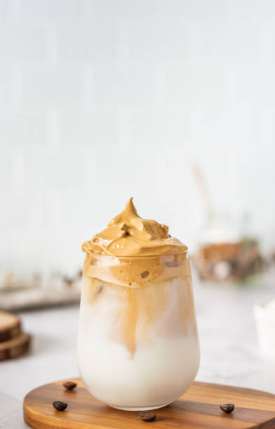 ふわふわのクリームを添えたダルゴナコーヒーを木製のトレイに添えて。ソーシャルメディア上の自家製トレンディな飲み物メニュー - latté coffee tray froth ストックフォトと画像
