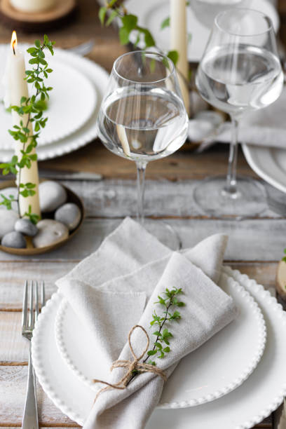 istock Rustic zero waste wedding decor with natural elements. Wooden table, candles, linen napkins, branches with green leaves. Eco-friendly decoration for the special dinner. Romantic and cozy place 1396186431