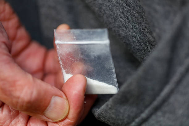 opiáceo de fentanilo heroína en bolsa de plástico en primer plano de mano en el bolsillo - fentanyl fotografías e imágenes de stock