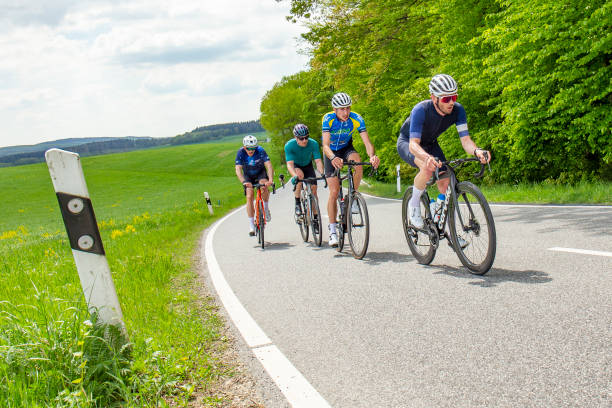 группа велогонщиков проведет гонку в красивом районе рейнгау в германии - road cycling стоковые фото и изображения