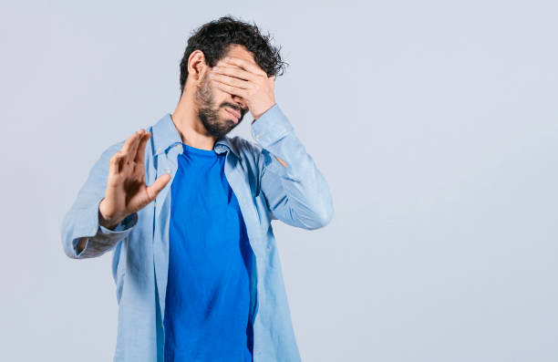 istock Scared confused man closing eyes with palm of hand 1396195078