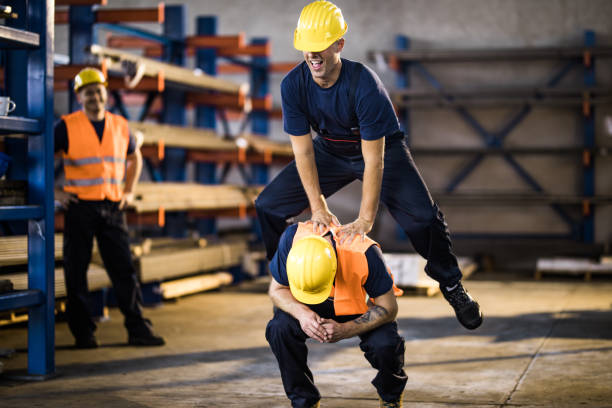 istock Playful manual workers playing leapfrog game on a break in a warehouse. 1396196134