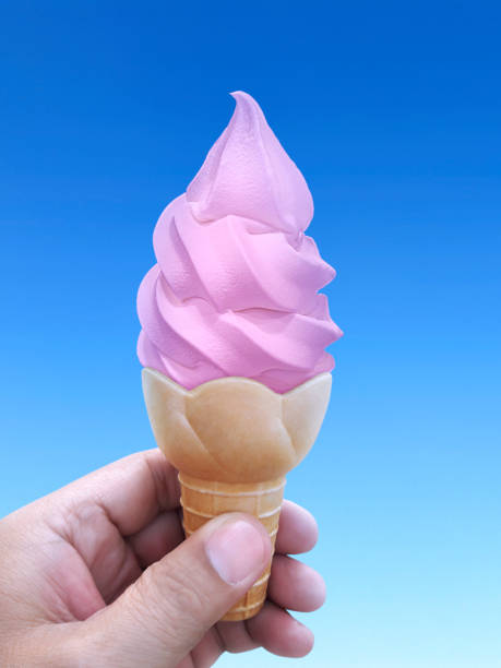 istock Man hand holding an ice cream cone on background. the blue sky 1396196838