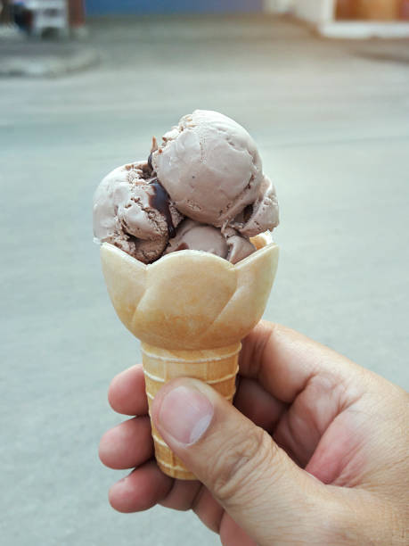 istock A man hand holding an ice cream cone on a white background 1396196878