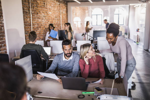istock Happy business people cooperating while working at corporate office. 1396197822