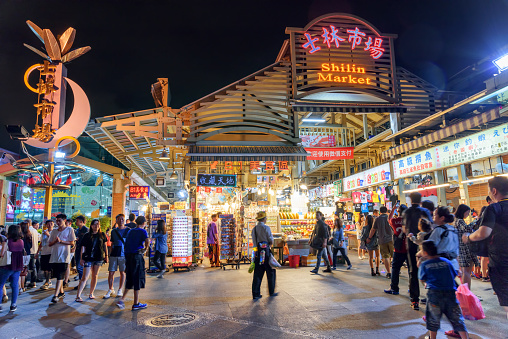 Taipei, Taiwan - April 26, 2019: Evening view of tourists walking along Shilin Night Market. The night market is a popular tourist destination and famous shopping area of Asia.